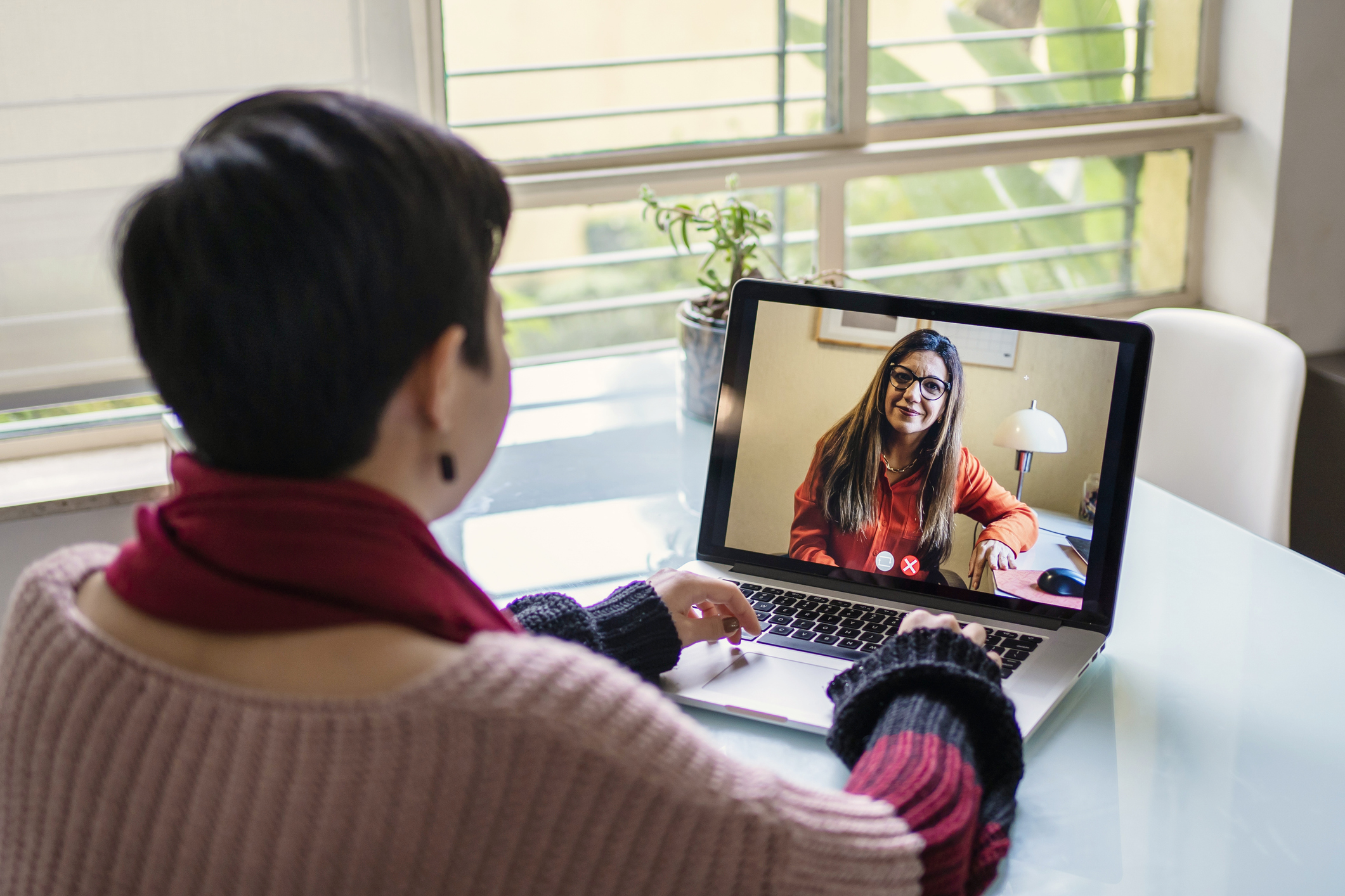 Woman speaking to healthcare provider on laptop