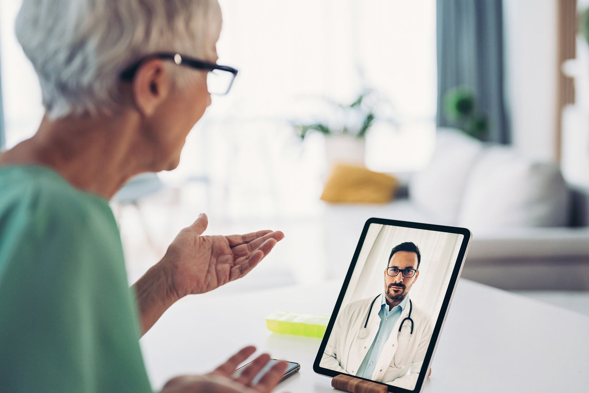 Woman on a telehealth call with her doctor on an a tablet