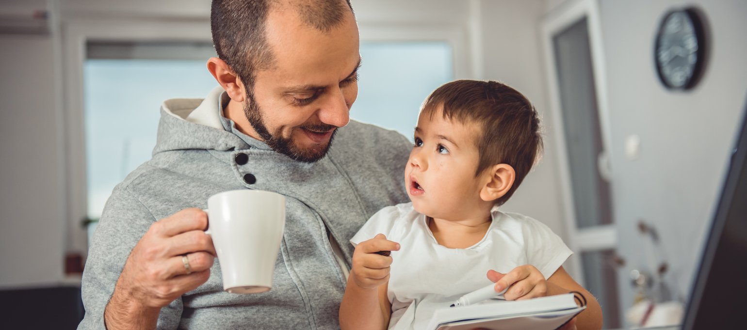 father working at home with child